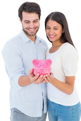 Happy couple holding their piggy bank