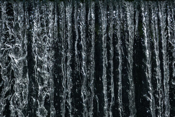 Close-up of light sparkling on cascading water that is flowing over a weir.