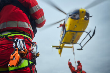Selective focus on safety harness of paramedic of emergency service in front of helicopter. Themes rescue, help and hope.. - 587356349
