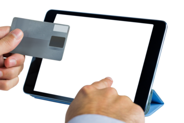 Person holding credit card while using digital tablet