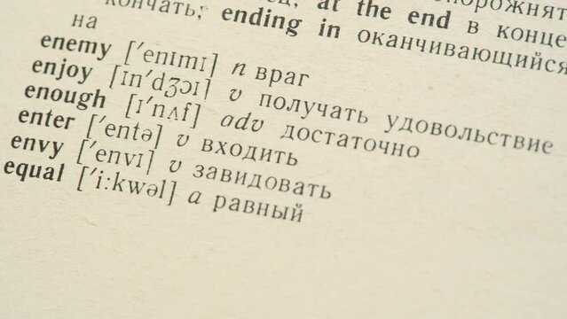 English and Russian language dictionary entries, different words, translations, book lines detail, macro, extreme closeup, pan. Text translation, differing cultures, learning languages, pronunciation