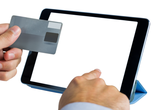 Person holding credit card while using digital tablet
