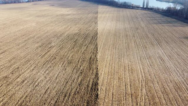 Half of large field after wheat harvest, half of field plowed. Flying over field with dry straw from wheat and brown dug up earth. Natural agricultural background. natural farming industrial backdrop.