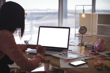 Businesswoman working on laptop at office desk