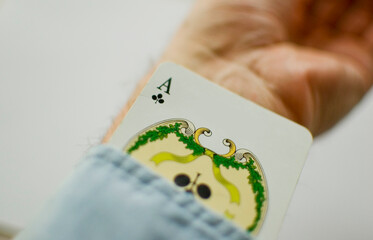 Mans hand hiding ace in the sleeve.