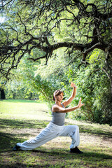 Beautiful woman doing Tai Chi in park.