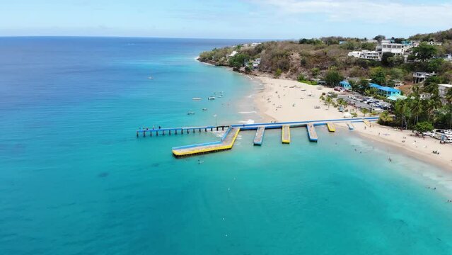 Ruinas de muelle en playa con arena blanca y aguas cristalinas