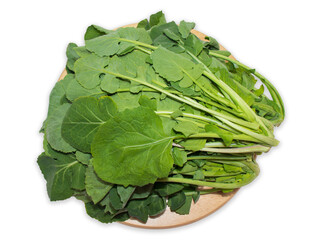 Rapeseed(canola) leafy vegetables on a round wooden cutting board on a white background with clipping path.