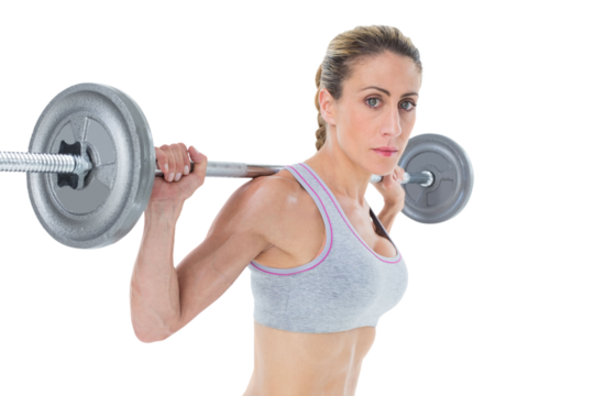 Strong female crossfitter lifting barbell behind head looking at camera