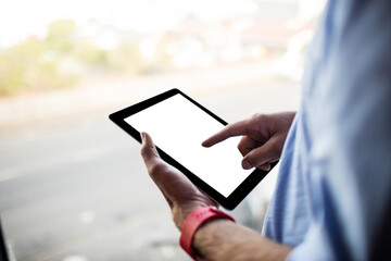 Man using digital tablet by window