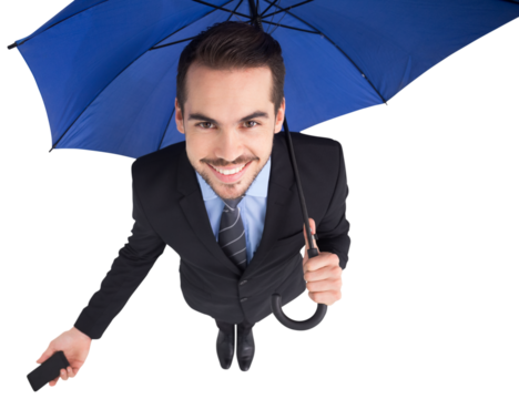 Smiling businessman under umbrella holding smartphone - Powered by Adobe