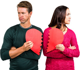 Serious couple holding cracked heart shape