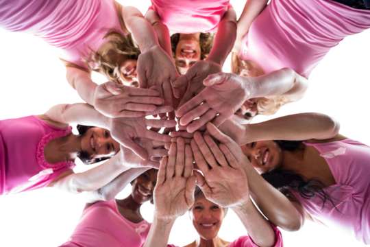 Directly below portrait of females in pink outfits stacking hands for breast cancer awareness
