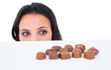 Pretty brunette peeking at chocolate