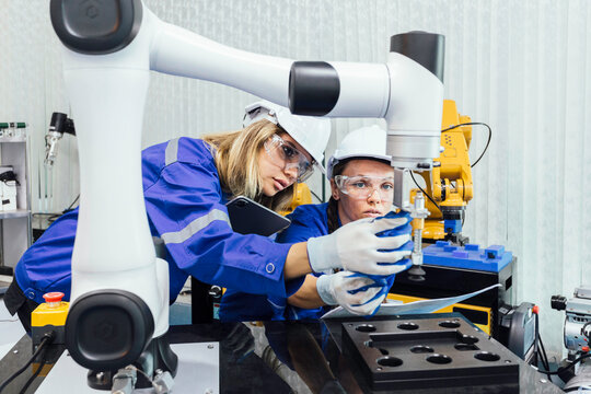 female automation machine engineer student study and inspection control robot arm machine in university or factory workshop. ai robot technology new innovation trend of manufacturing in industry 5.0