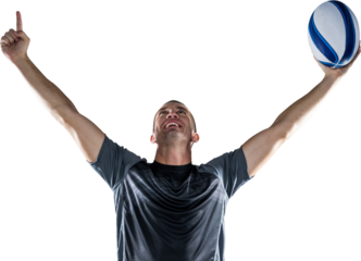 Successful rugby player holding ball with arms raised