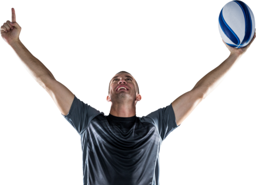 Successful rugby player holding ball with arms raised