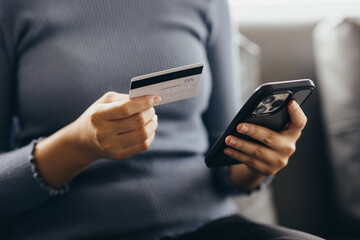 Close up of young woman holding credit card using smartphone online payment, home shopping, ecommerce, internet banking, spend money, finance, e-shop concept.