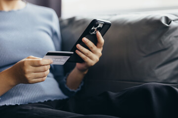 Close up of young woman holding credit card using smartphone online payment, home shopping, ecommerce, internet banking, spend money, finance, e-shop concept.