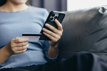 Close up of young woman holding credit card using smartphone online payment, home shopping, ecommerce, internet banking, spend money, finance, e-shop concept.