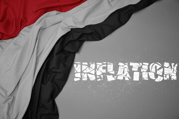 waving colorful national flag of yemen on a gray background with broken text inflation. 3d illustration