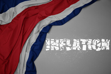 waving colorful national flag of costa rica on a gray background with broken text inflation. 3d illustration