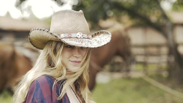sexy cowgirl wearing a hat on her ranch with her horse-SLOWMOTION