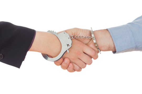 Business people in handcuffs shaking hands