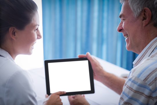 Female doctor and man smiling while holding digital tablet