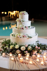 bellissima torta di panna decorata con i fiori e isolata sulo sfondo di una piscina 