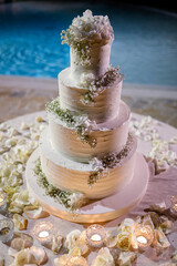 bellissima torta di panna decorata con i fiori e isolata su sfondo piscina