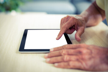 Male using digital tablet at table