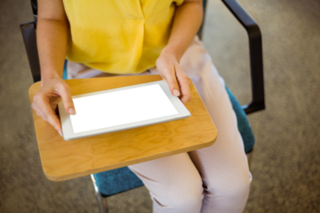 Mid section of female business executive using digital tablet