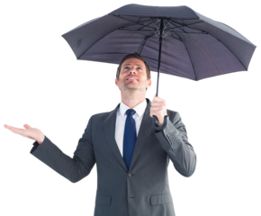 Businessman sheltering under black umbrella