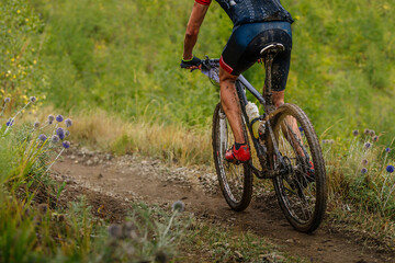 Fototapeta na wymiar male mountain bike cyclist riding on cross-country cycling, dirty drops on bike and clothes, race in cloudy trail