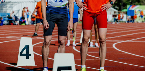 blind male runner with guide in starting line running sprint race, summer sports games
