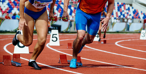 Fototapeta premium female blind runner with guide starting running sprint race, summer sports games