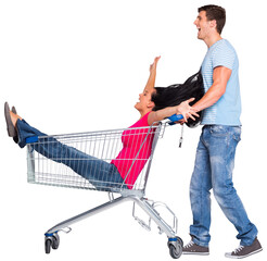Young couple having fun with shopping cart