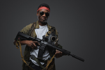 Shot of cheerful pirate of african ethnic with rifle in setting of post apocalypse.