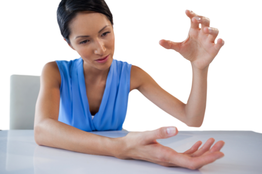 Businesswoman gesturing while holding something at table
