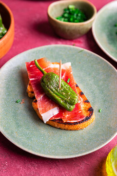 Bread toast tapas with jamon and padron pepper