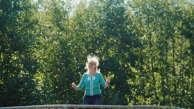 A Middle-aged Woman High Up On A Trampoline. Active Lifestyle. Slow Motion Video