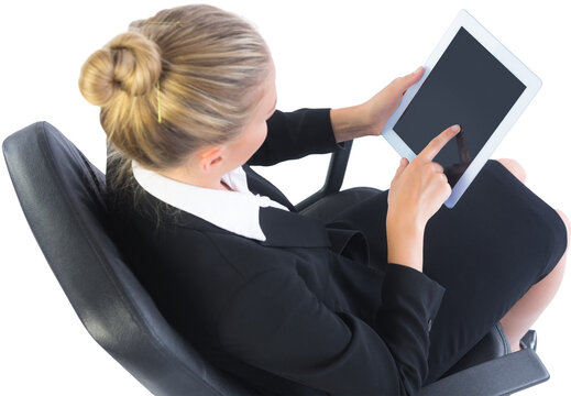 Businesswoman sitting on swivel chair with tablet