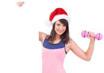 Festive fit brunette smiling at camera holding poster