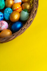 Fototapeta na wymiar Easter eggs with easter basket isolated on yellow background