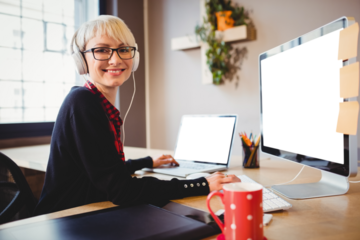 Portrait of female graphic designer working on computer and laptop