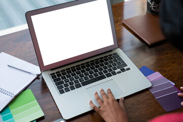 Cropped hand of woman using laptop at home