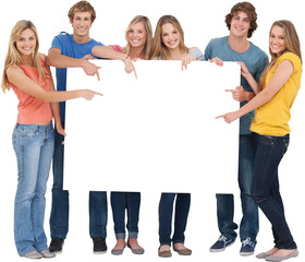 Obraz premium Smiling group of people with a blank space as they point to it