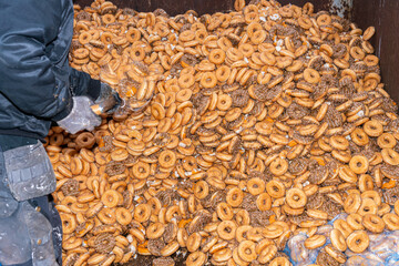 Many sweet and tasty round doughnuts, ring donuts covered with sugar. Chocolate-frosted doughnut. Symbol of sweeties, fried dough. A lot of sweet unhealthy food. Food waste, food production.