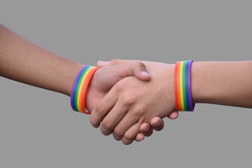 Isolated hands which wear rainbow wristband around them with clipping paths.